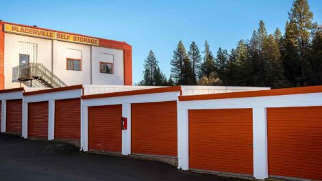 A row of garage doors on a slanted drive with the Placerville Self Storage sign in the back.
